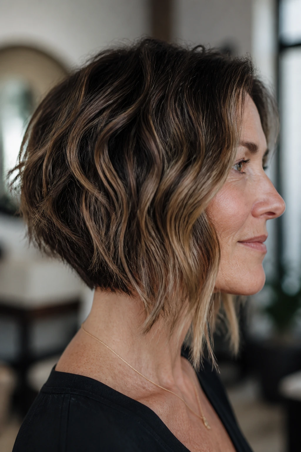 Side-profile of a real woman with angled bob illustrating the angle on wavy hair