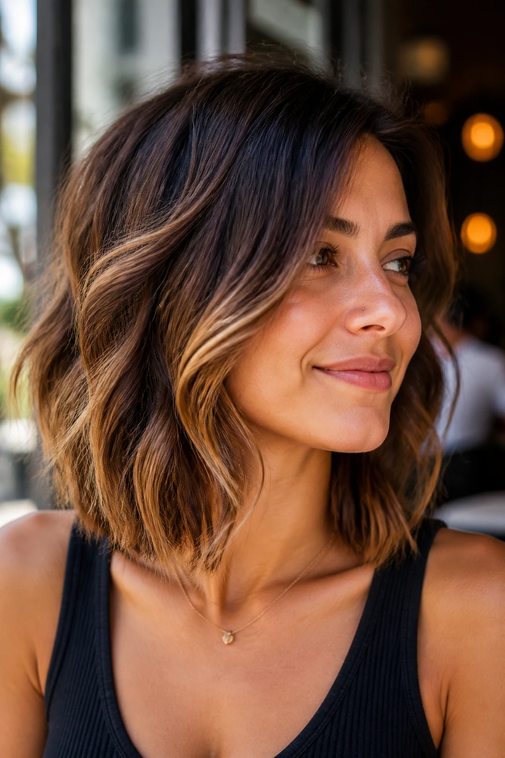 Close-up of a real woman with angled lob and honey-brown lowlights