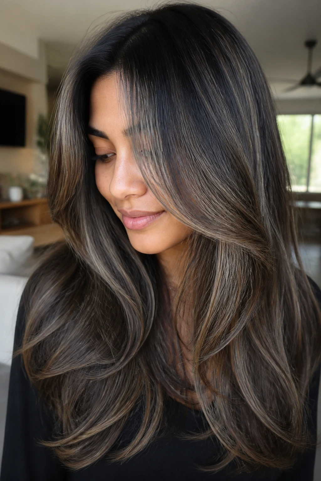 Real person with long layered hair showing ash balayage on tan skin