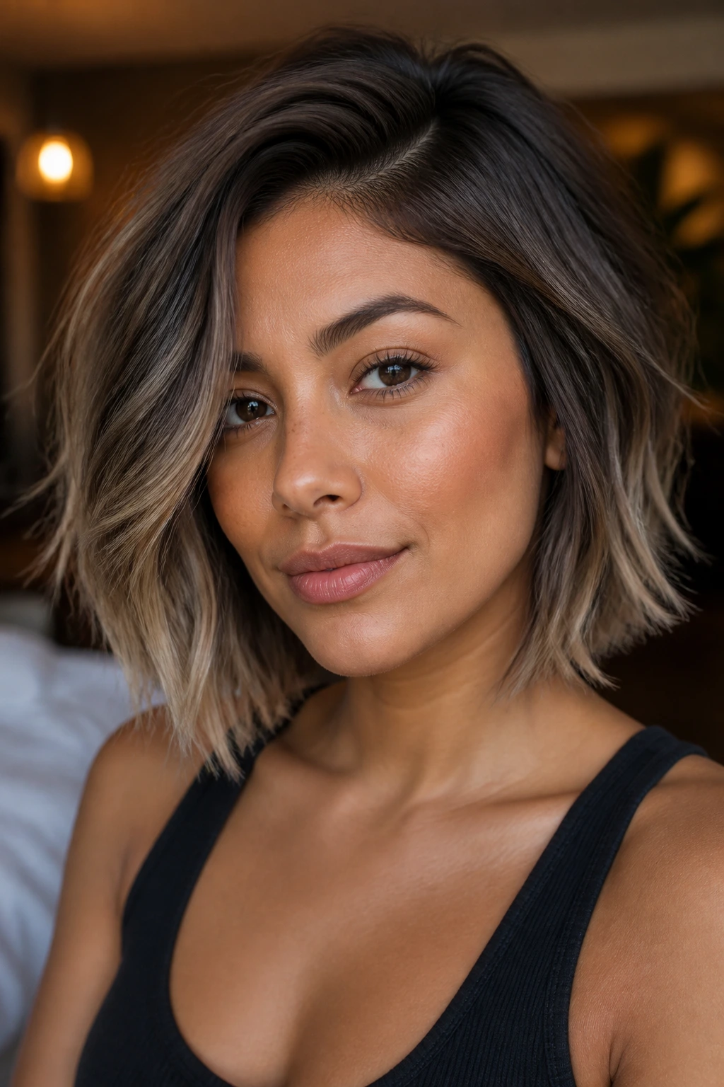 Real woman with ash brown champagne ends short cut in warm indoor light