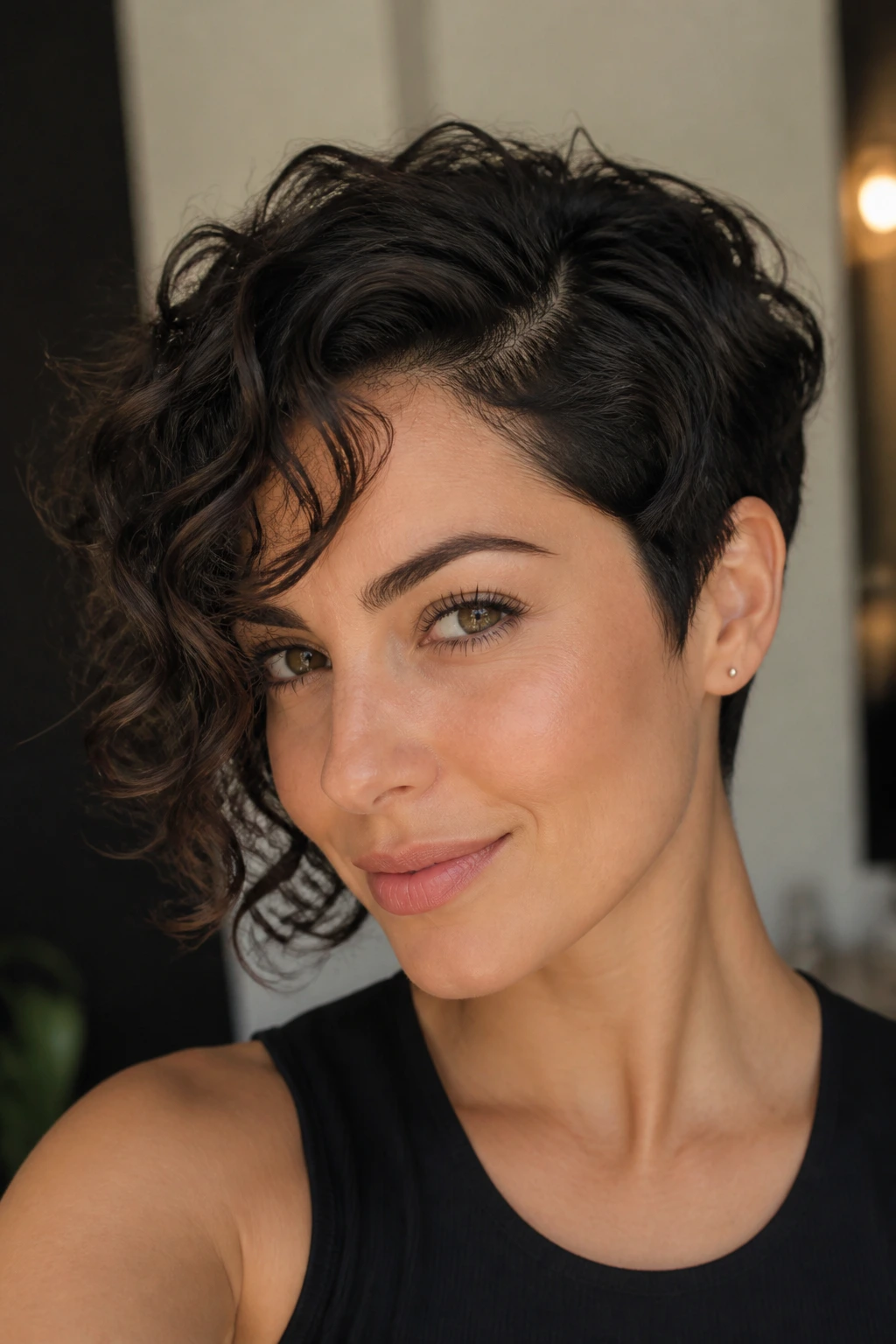 Portrait of a person with asymmetrical curly pixie and deep side part
