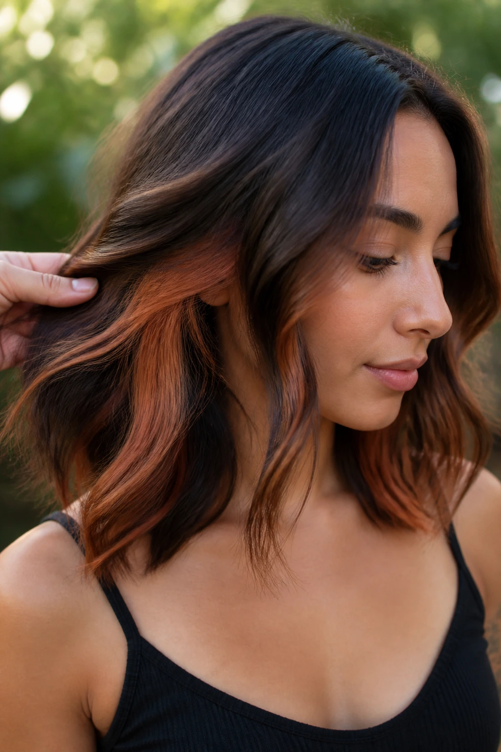 Real woman with auburn peekaboo panels on wavy midi hair
