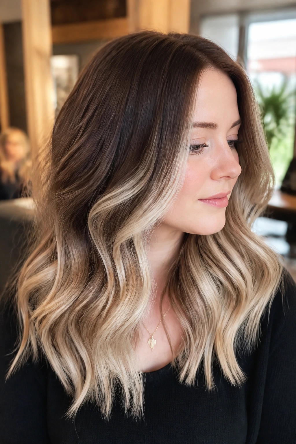 Close-up of woman with cocoa-root balayage and milk-blonde ribbons in soft waves