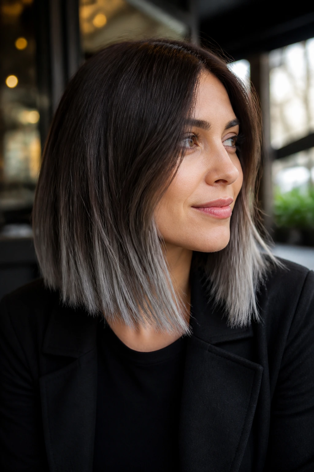 Close-up portrait of a woman with a cocoa-to-steel lob hair color