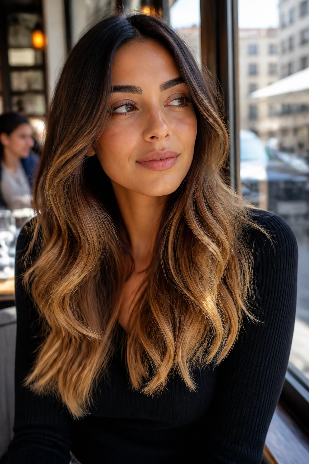 Close-up of a real woman with soft golden ombré balayage on brunette hair
