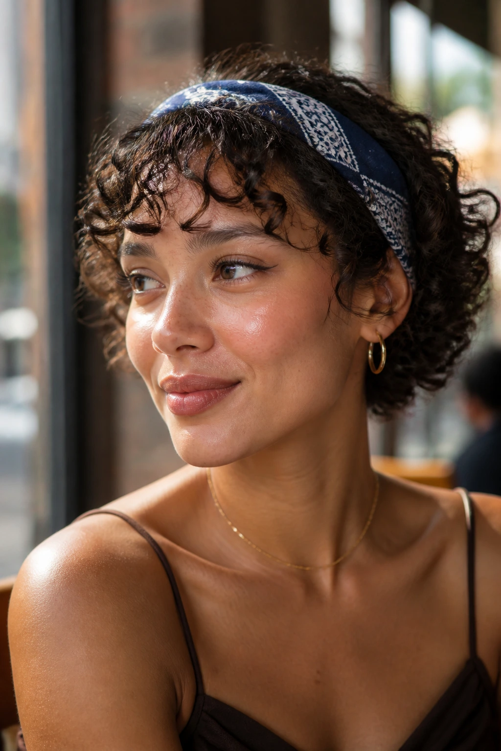 Close-up portrait of a person wearing a bandana over a short curly bob