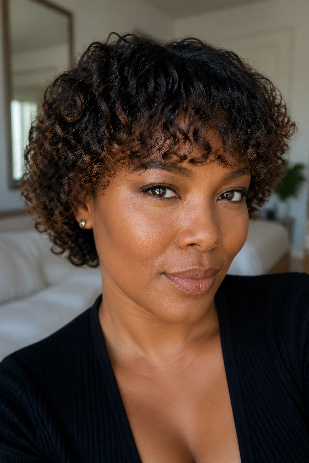 Close-up of a real woman's bangs with a clean, curved finish and subtle lowlights.