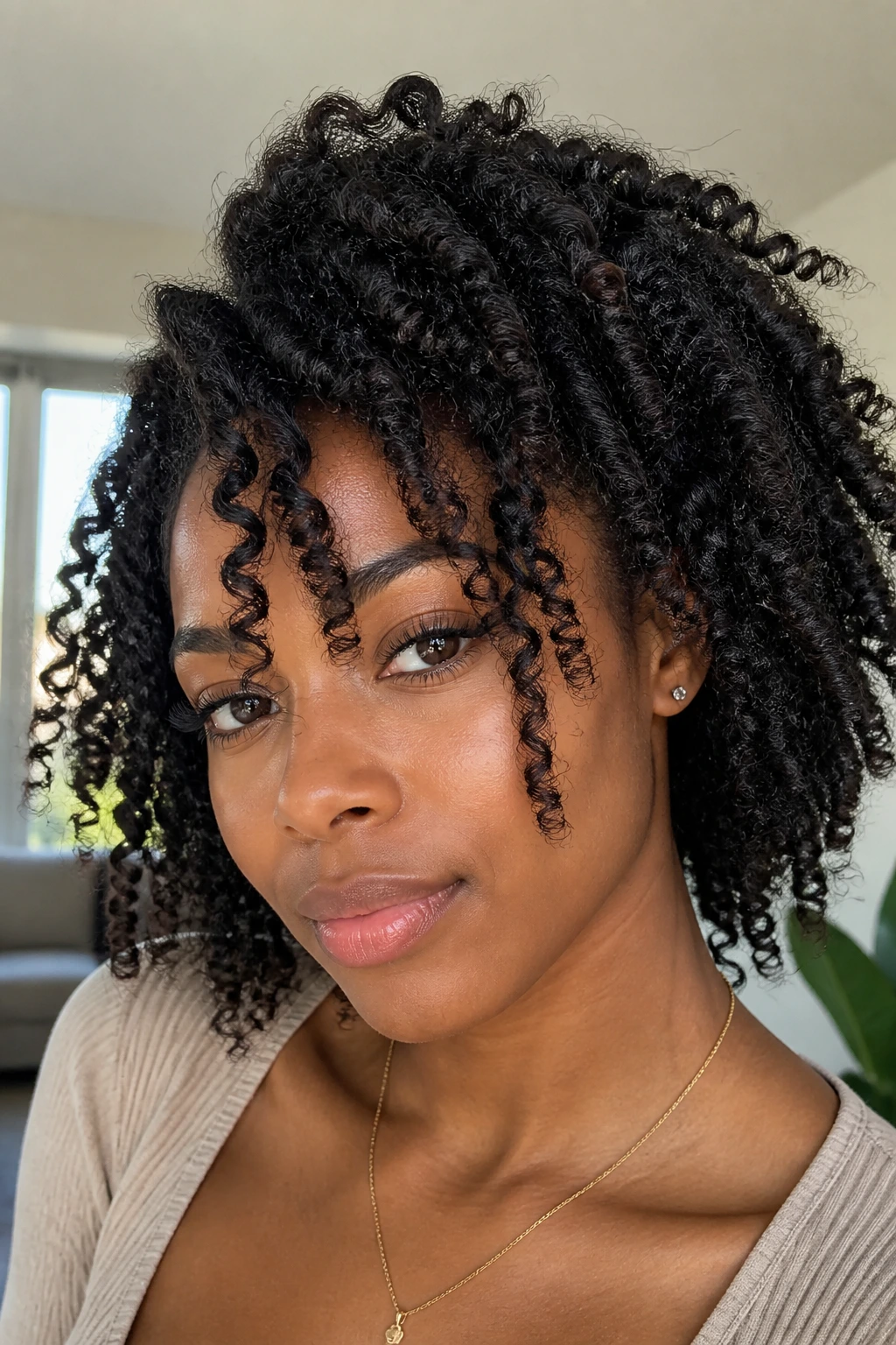 Close-up of a real Black woman with a Bantu knot-out and piecey ends framing the face