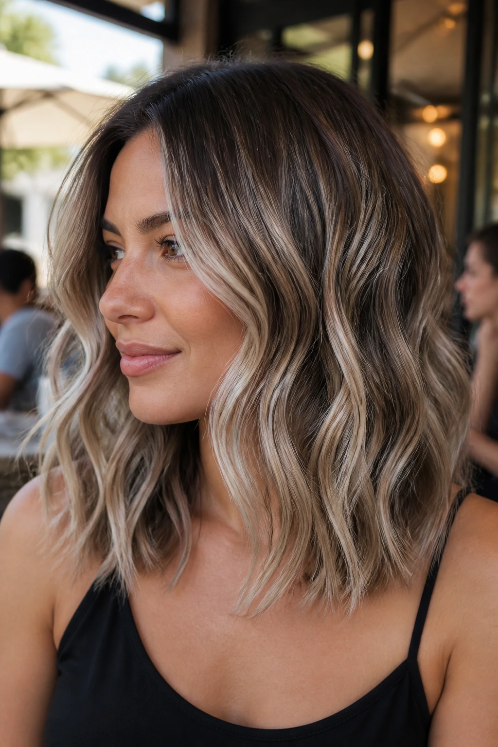Close-up of beige ice balayage on wavy shoulder-length hair on a real person