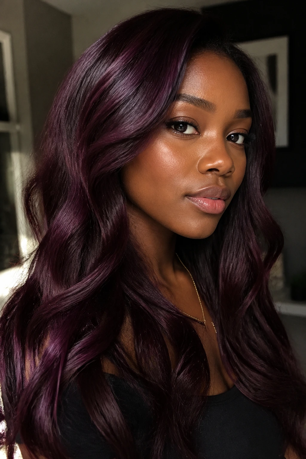 Real person wearing blackberry merlot hair with cool depth and berry red highlights
