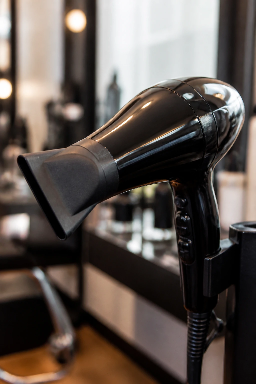 Close-up of a professional blow dryer nozzle in a salon setting.