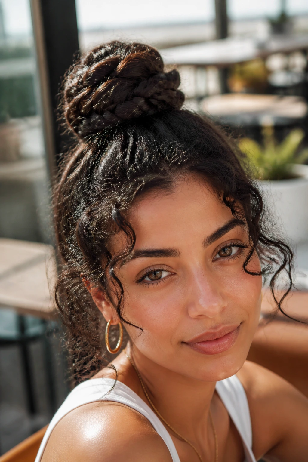 Close-up portrait of a real woman with a high braided top knot.