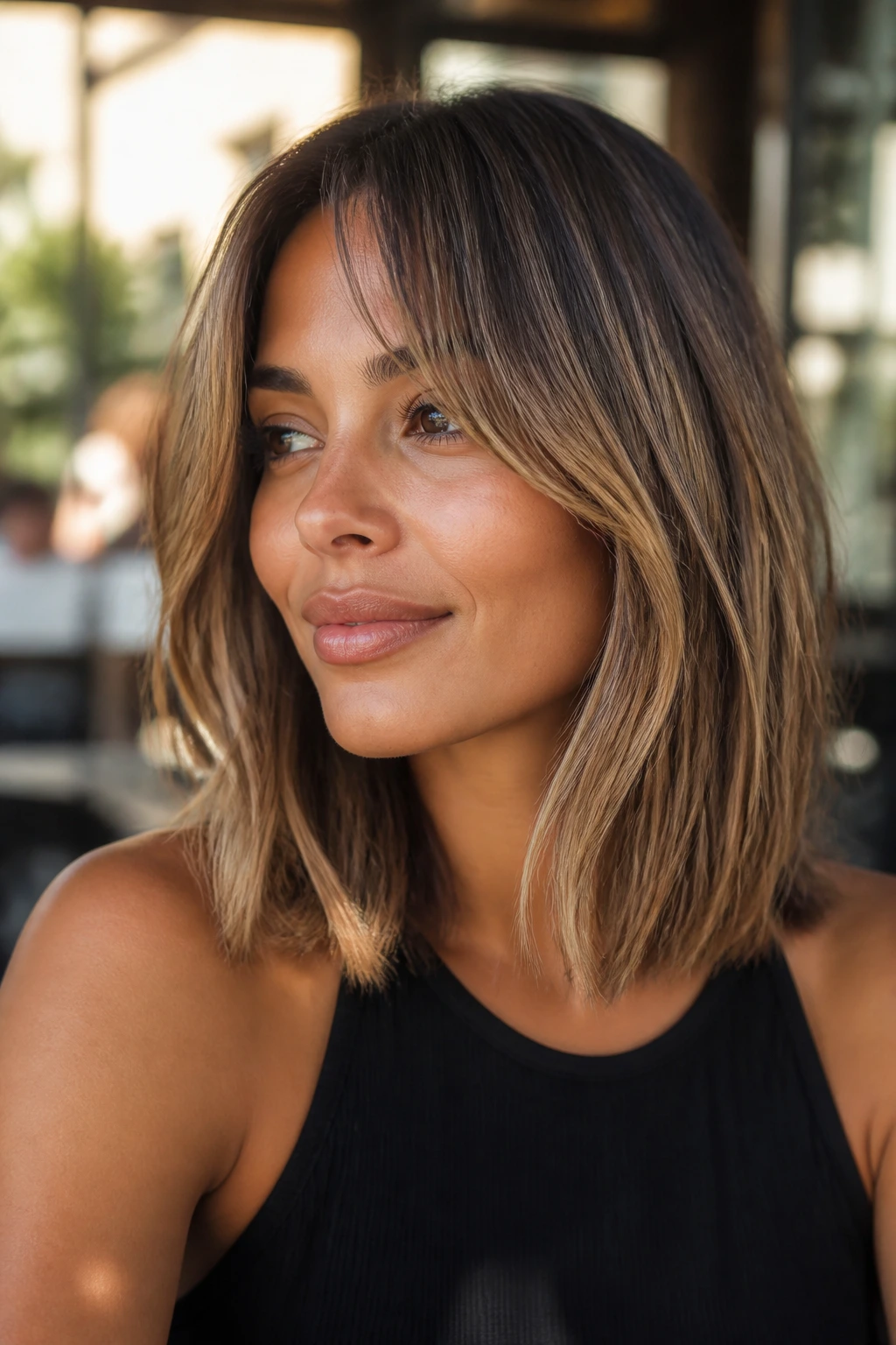 Close-up of a real woman with bronde curtain bangs and a lob haircut