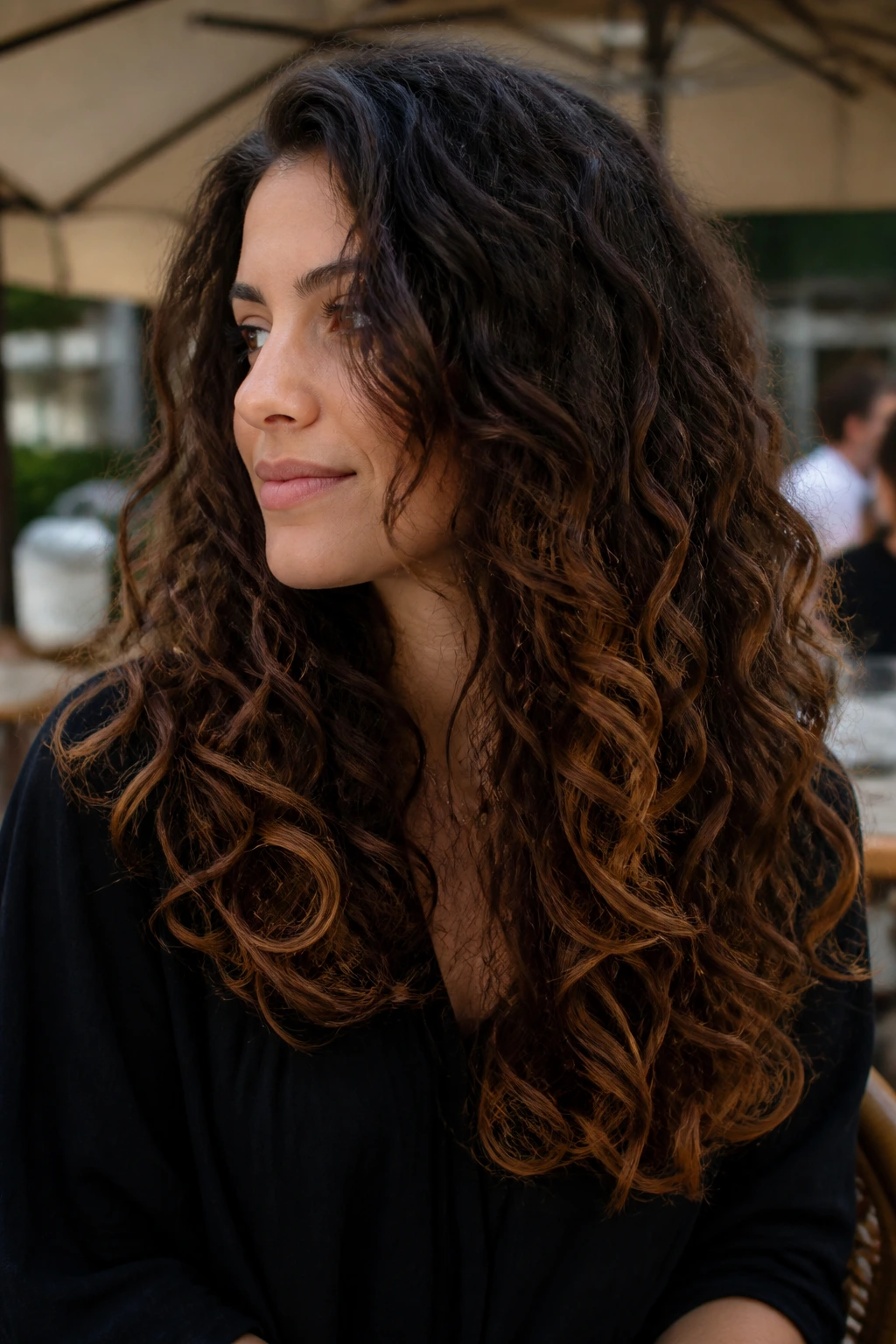 Real woman with bronze tip sweep on long brunette curls close-up