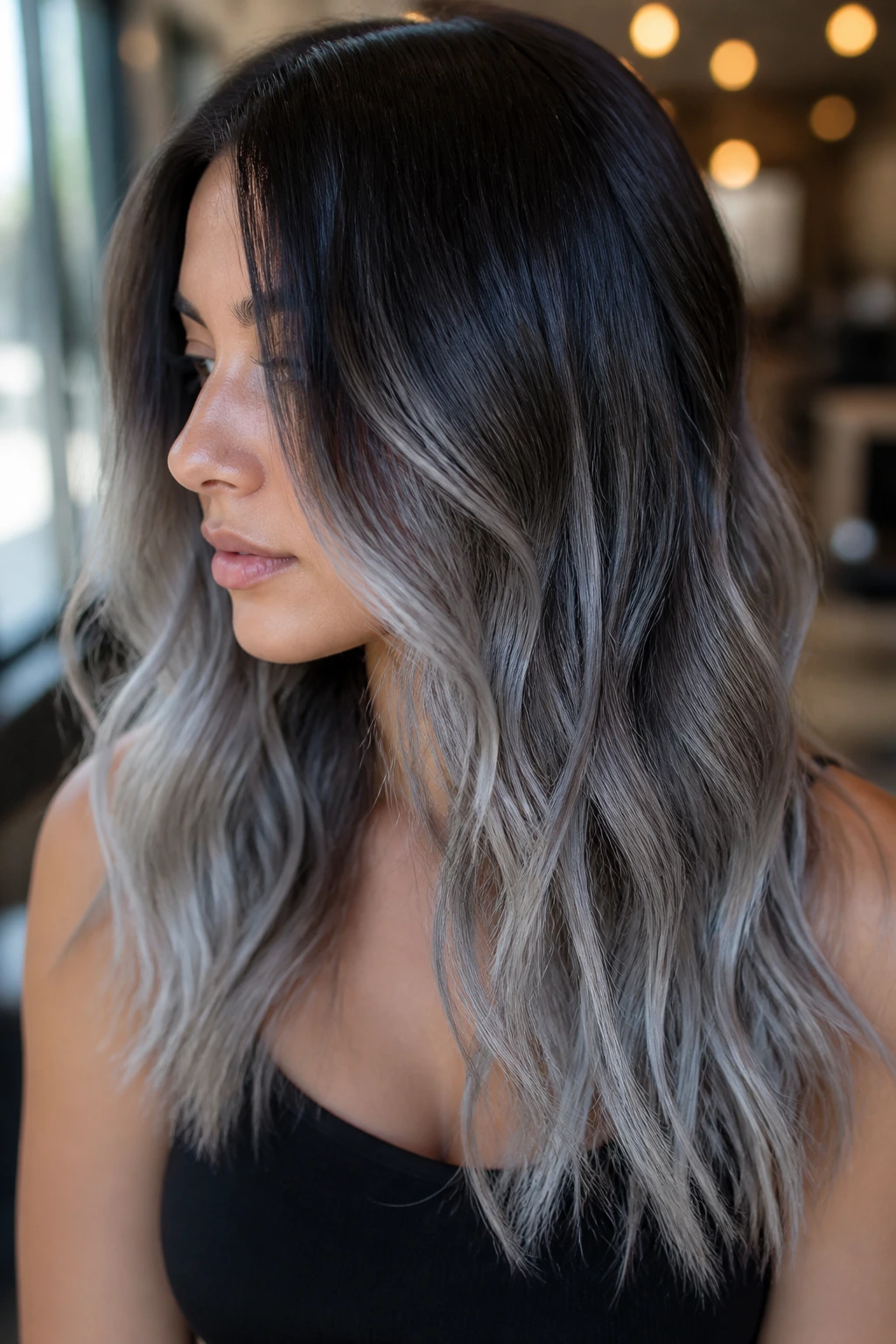 Close-up brunette with deep roots blending into silver ends