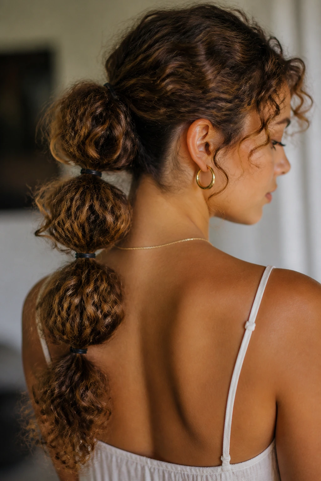 Portrait of a real woman with a bubble ponytail and curly segments