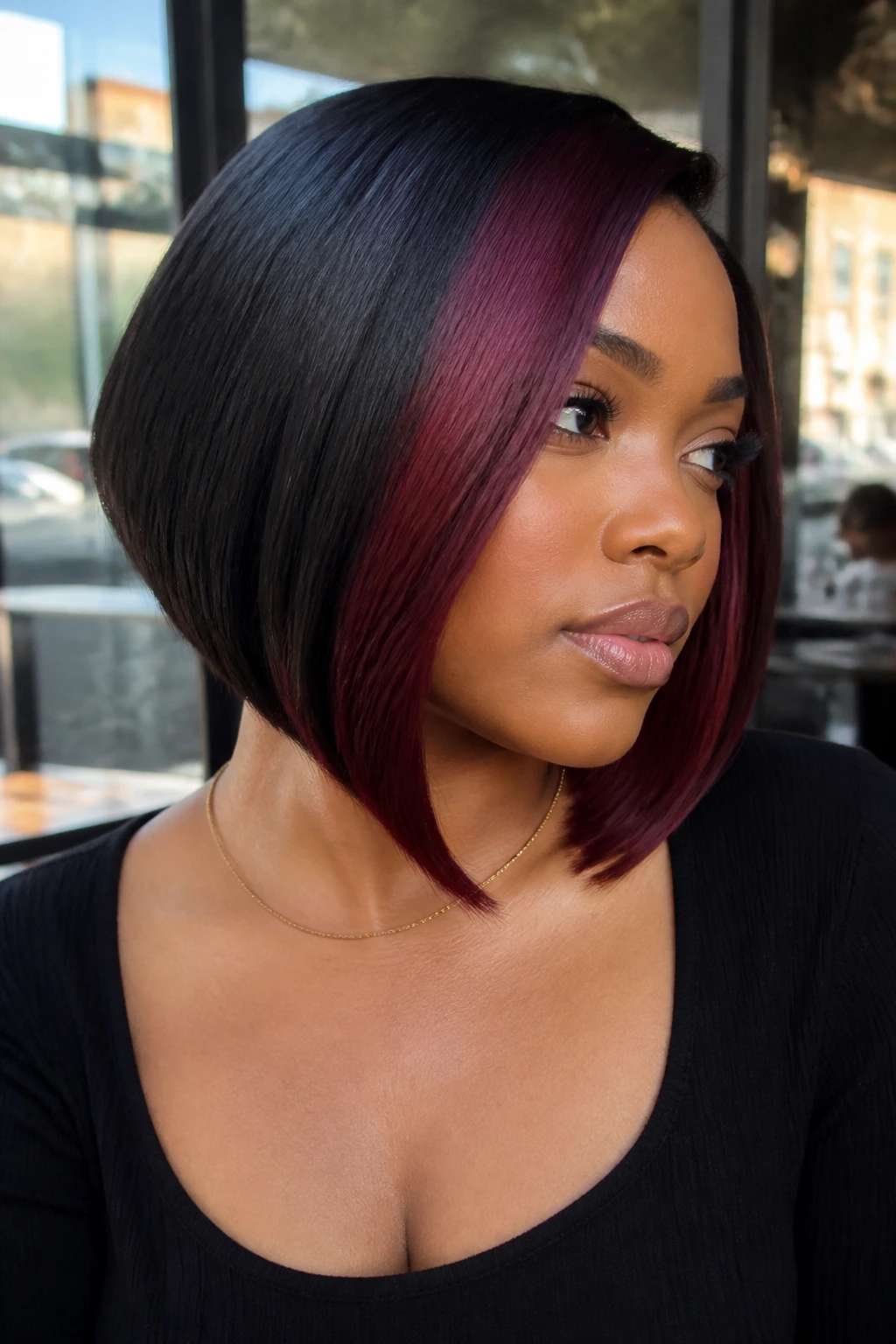 Close-up portrait of a real Black woman with burgundy color-blocked bob and thick hair