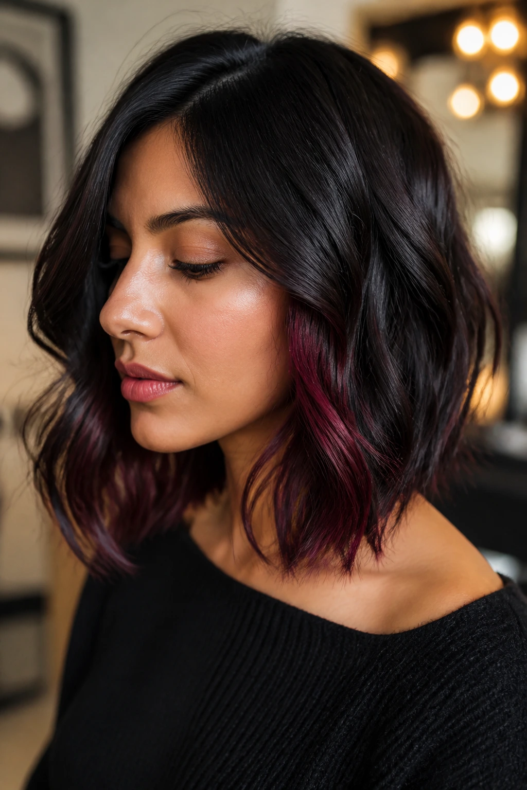 Close-up of real woman with burgundy peekaboo underlayers in a dark lob