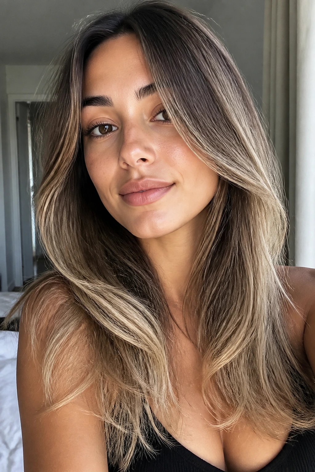 Close-up of a real person with face-framing layers and buttery ends in natural light
