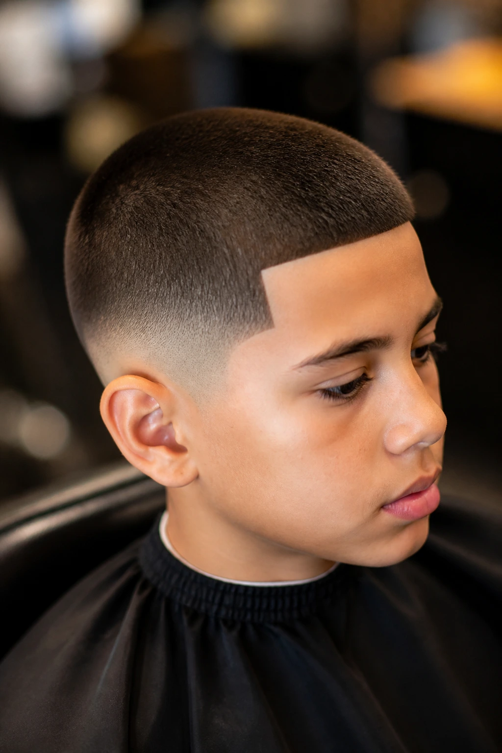 Close-up of a real boy with a buzz cut and sharp line-up in a barbershop