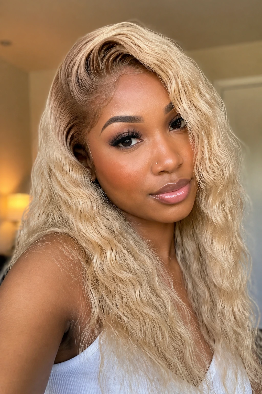Woman with champagne blonde water wave wig and side part.