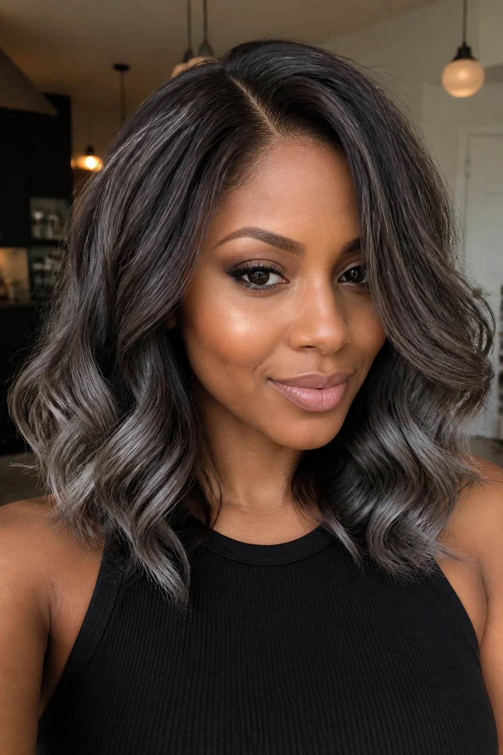 Close-up of a person with charcoal melt hair showing deep roots and smoky silver ends.