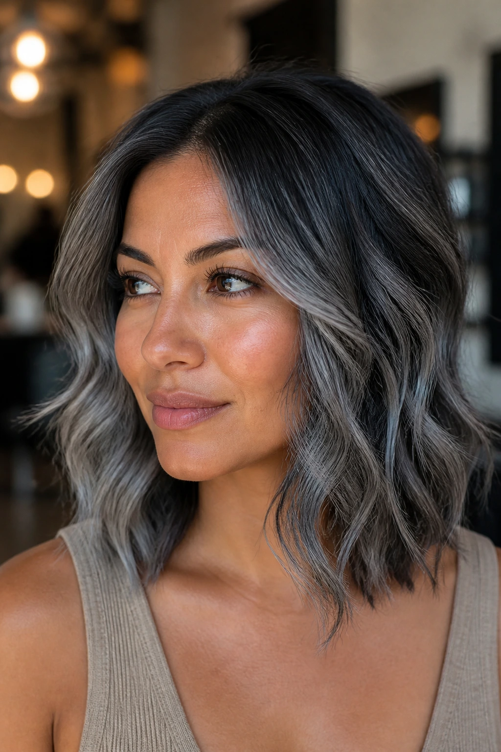 Close-up of a person with medium skin and a charcoal root melt hairstyle