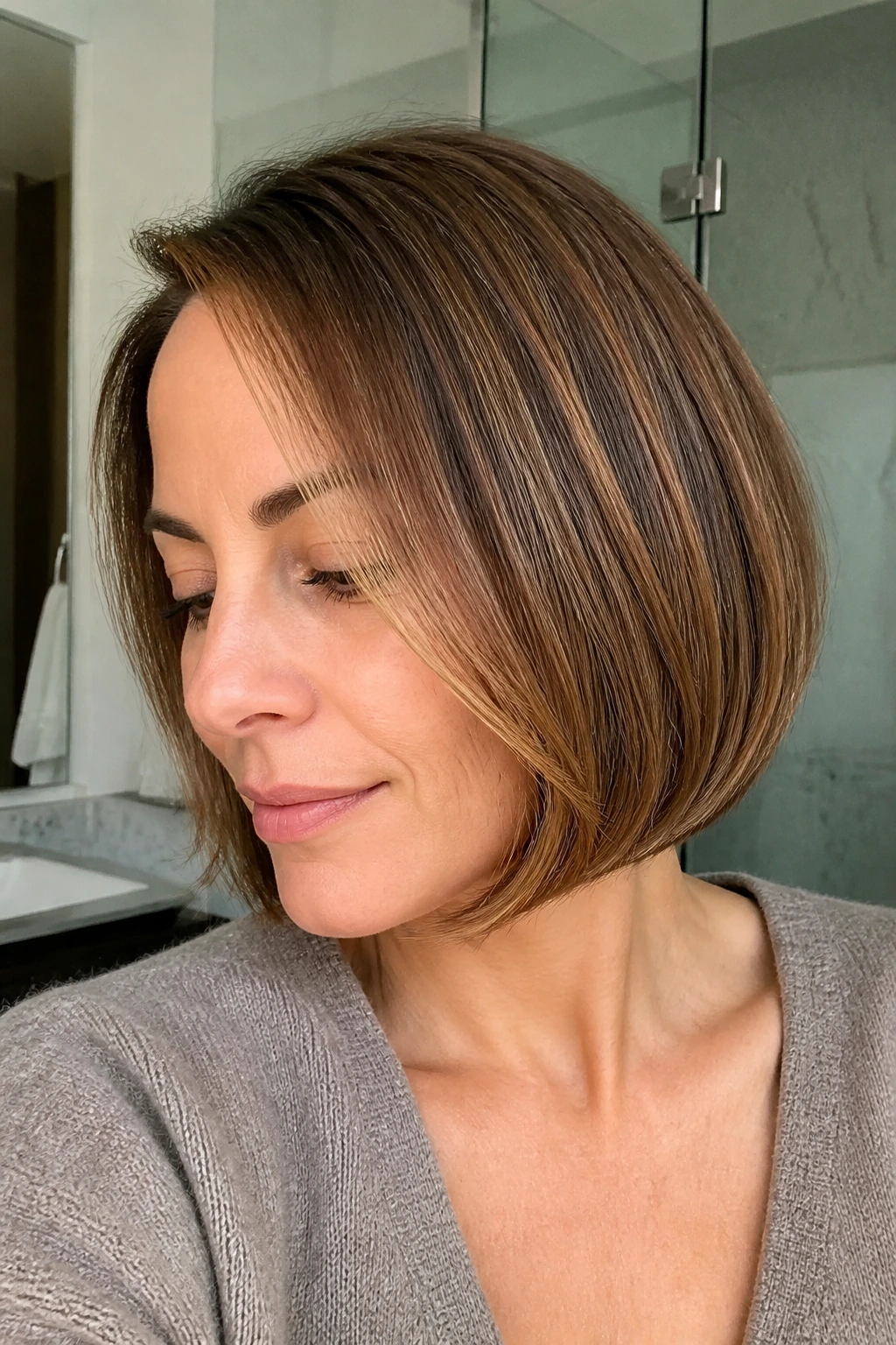 Close-up of a real woman with a chin-length bob and tucked ends with caramel around the face