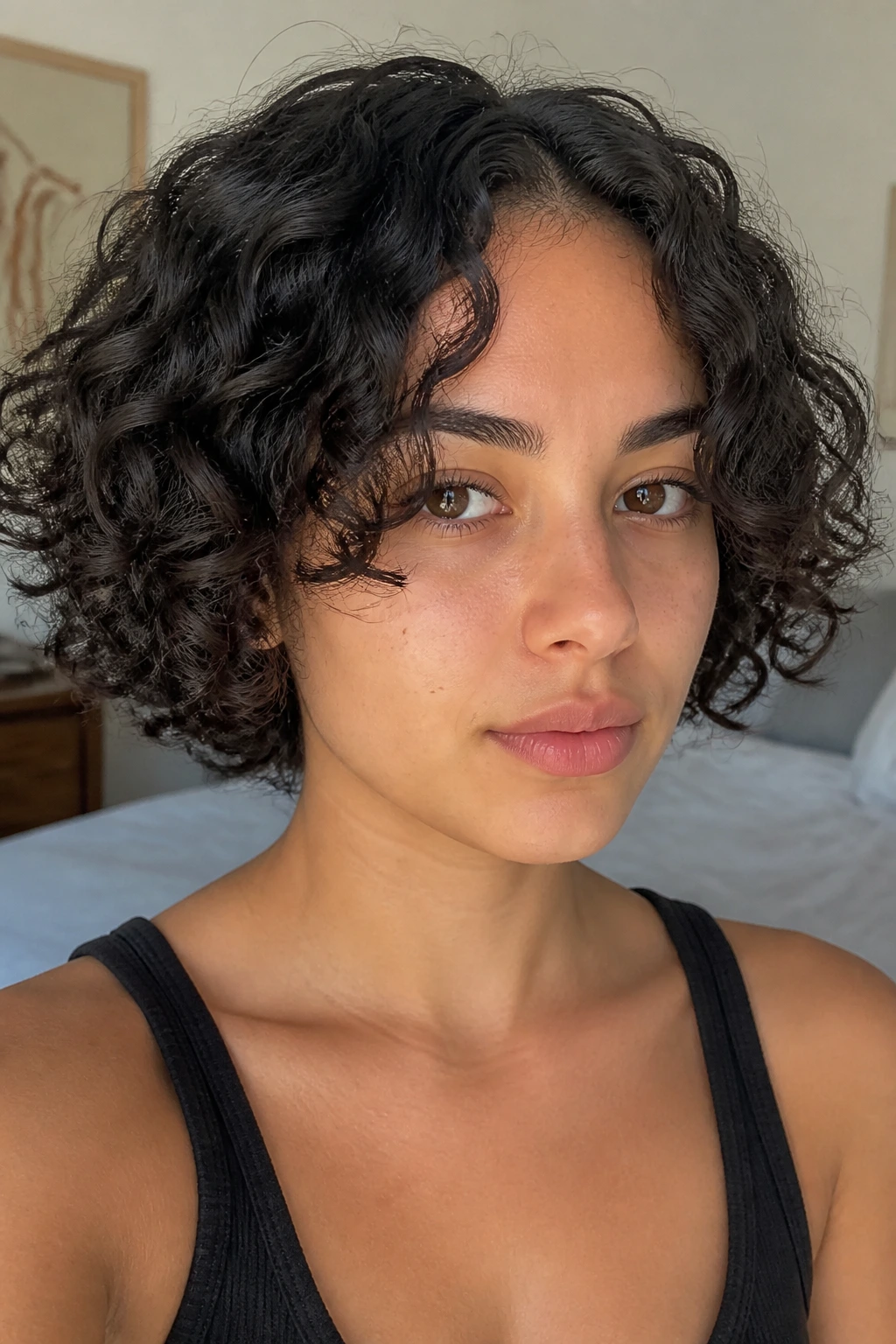 Close-up of a person with chin-length curls and center-part curtains framing the face