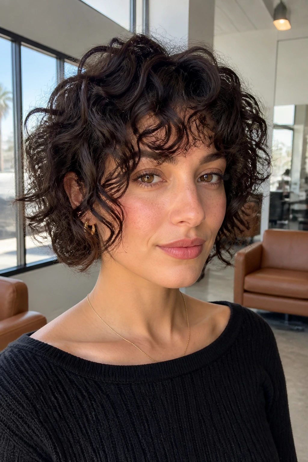 Real woman with chin-length curly shag and jaw-skimming pieces in bright salon
