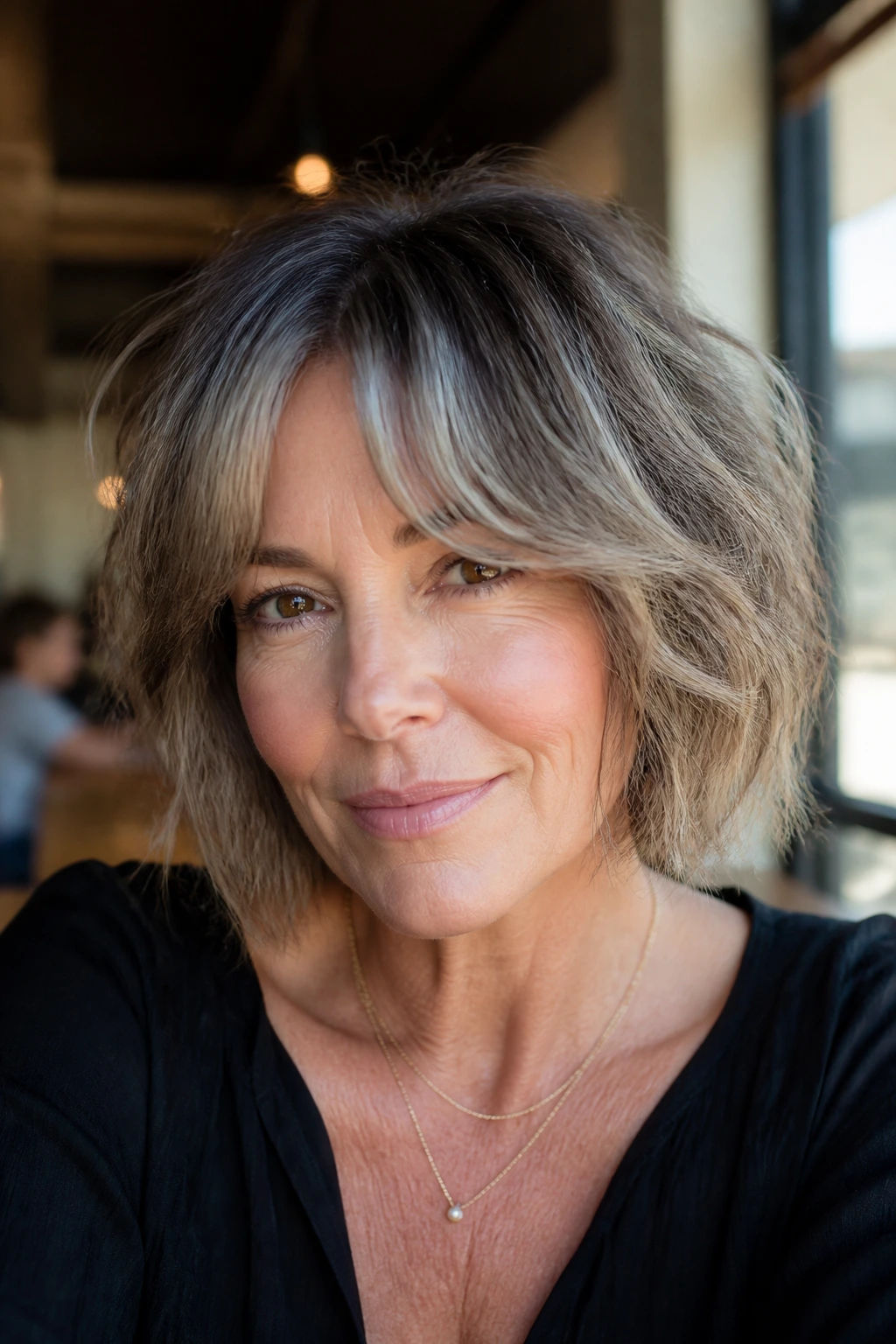 Close-up of a real woman with a choppy bob and textured curtain fringe.