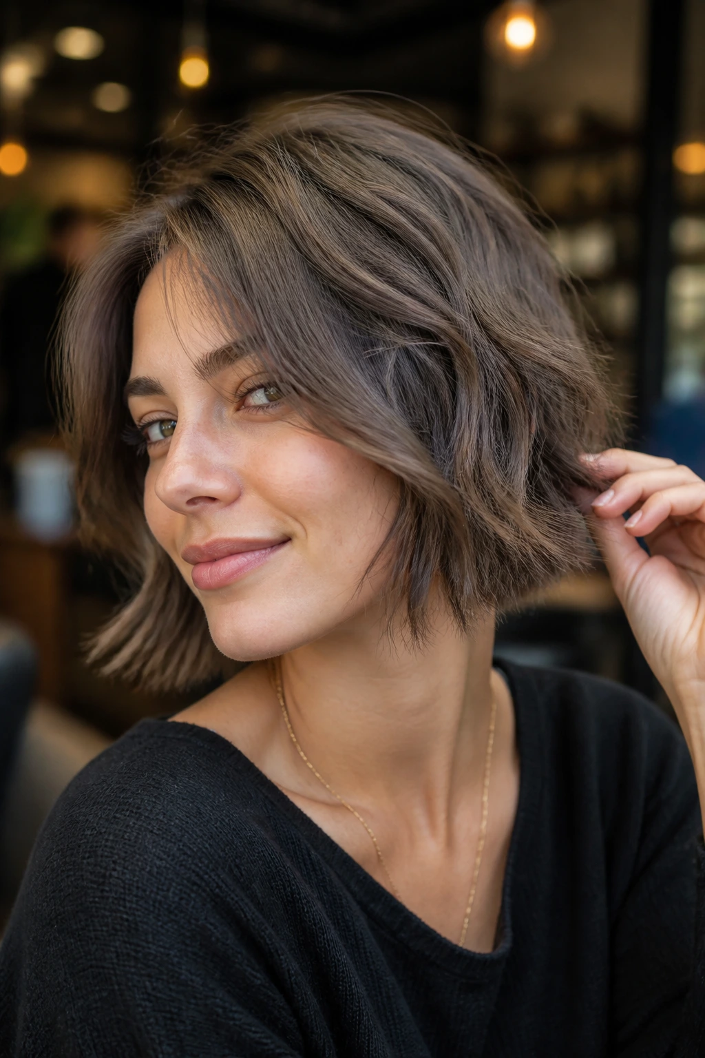 Real woman with a choppy chin-length cut and airy textured ends in ash brunette