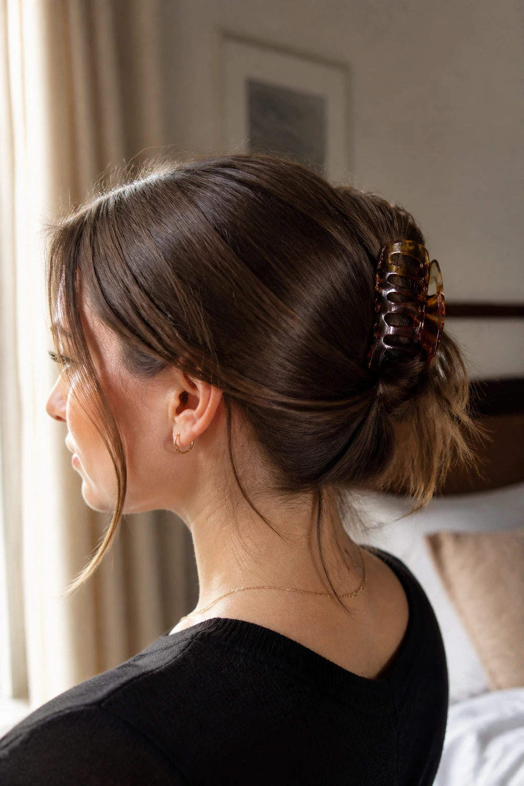 Close-up of a real woman showing a claw-clip pony hybrid hairstyle with a folded tail and loose pieces at the neck.