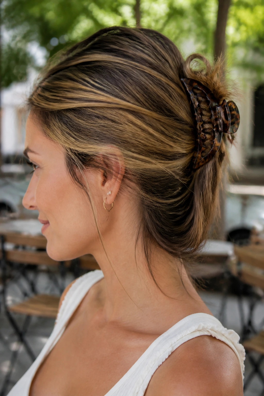 Close-up of real woman with a claw-clip twist on a grown-out bob and lowlights.