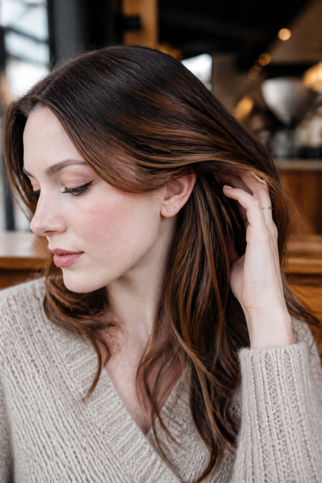 Close-up of a real woman with cocoa peekaboo panels peeking through top hair against pale skin