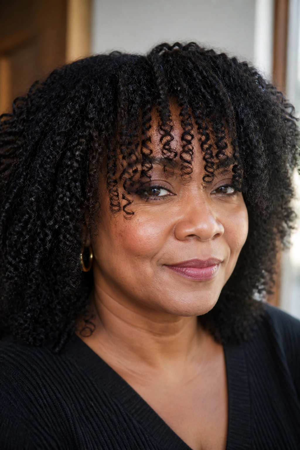 Close-up of a real woman with micro-shaped long bangs on coils.