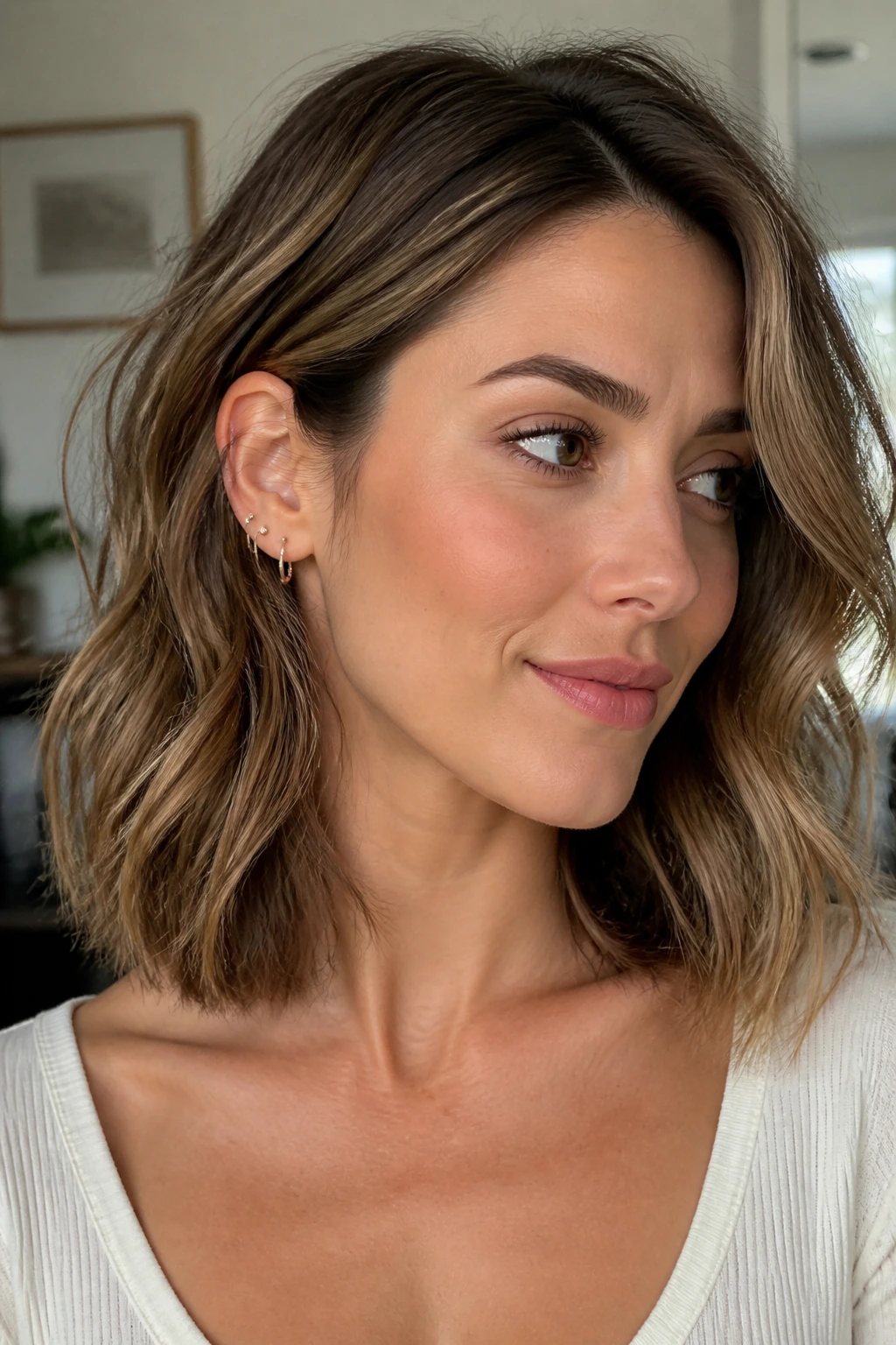 Close-up of a real woman with collarbone-length lob and hidden layers creating motion.
