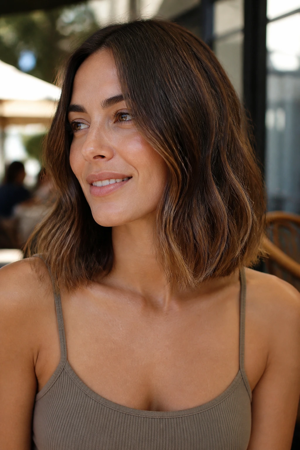 Real woman with collarbone-skimming lob and subtle end texture in natural cafe light
