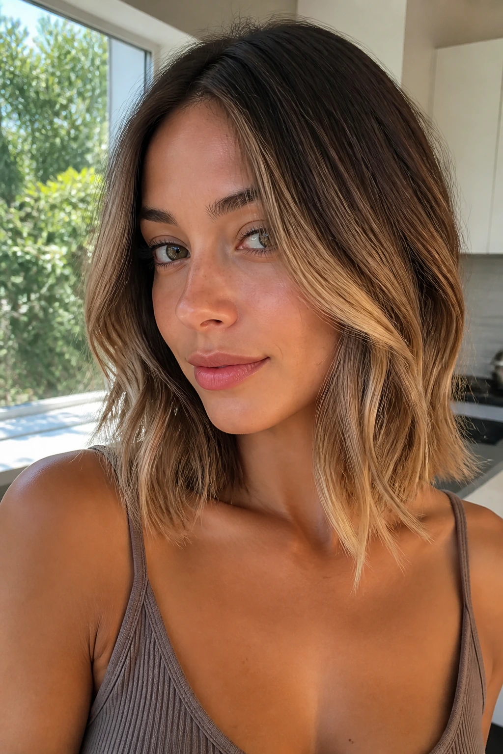 Close-up portrait of a real woman with collarbone-length cut and sunlit ends