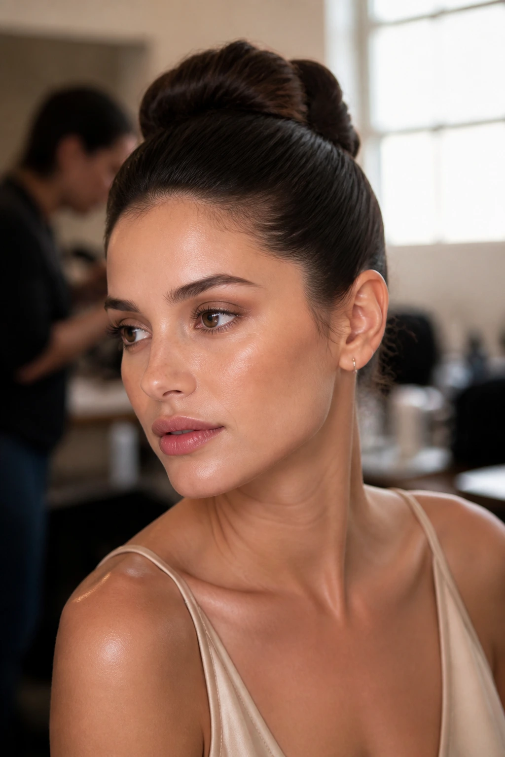 Real woman with comfortable, secure sleek updo in backstage lighting