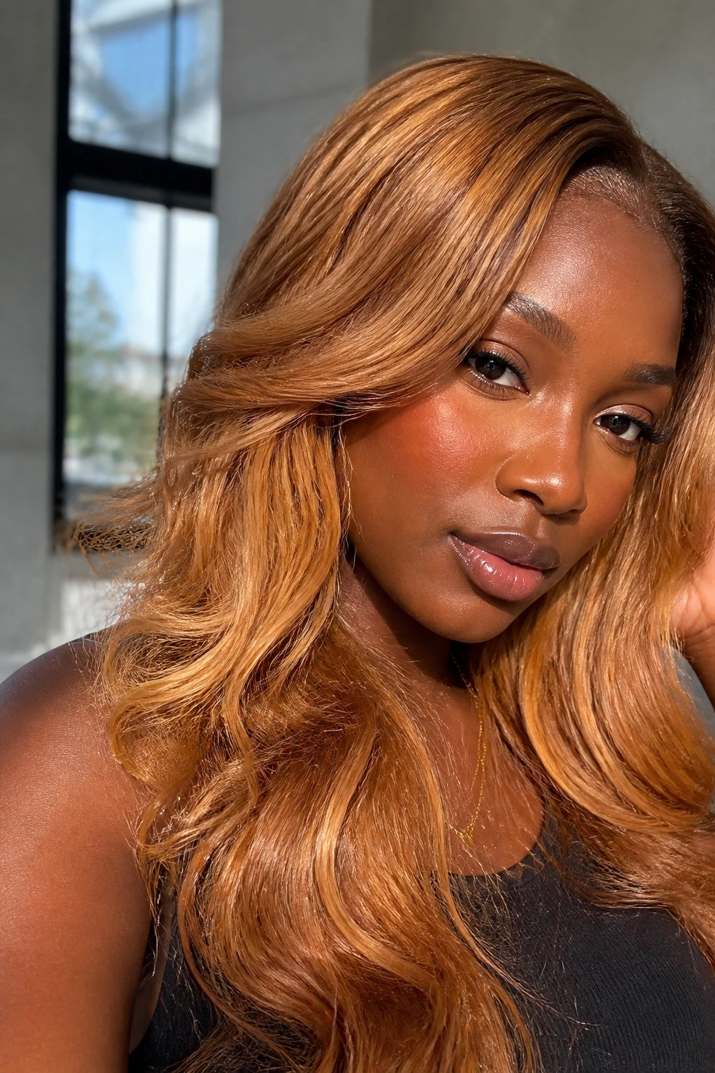 Close-up portrait of a person with deep skin tone and copper-honey blonde hair in daylight