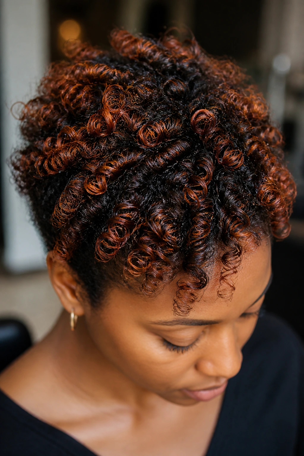 Close-up of defined coils with copper threading on dark natural hair