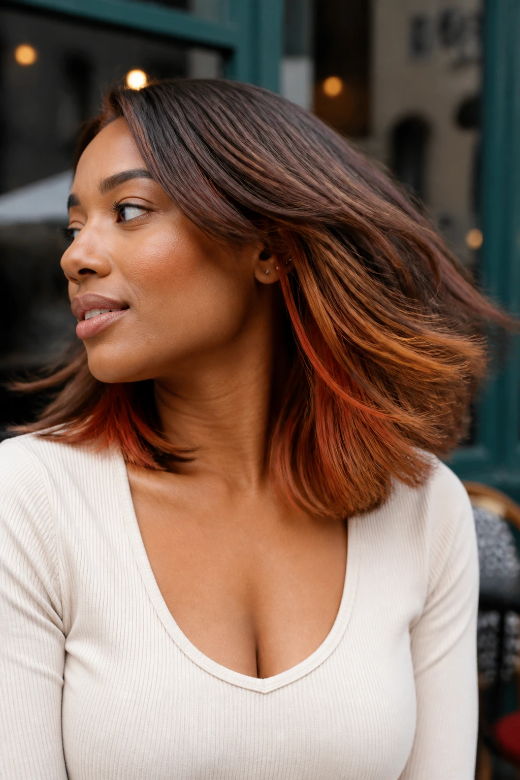 Close-up of a person with copper underlights visible when hair moves.