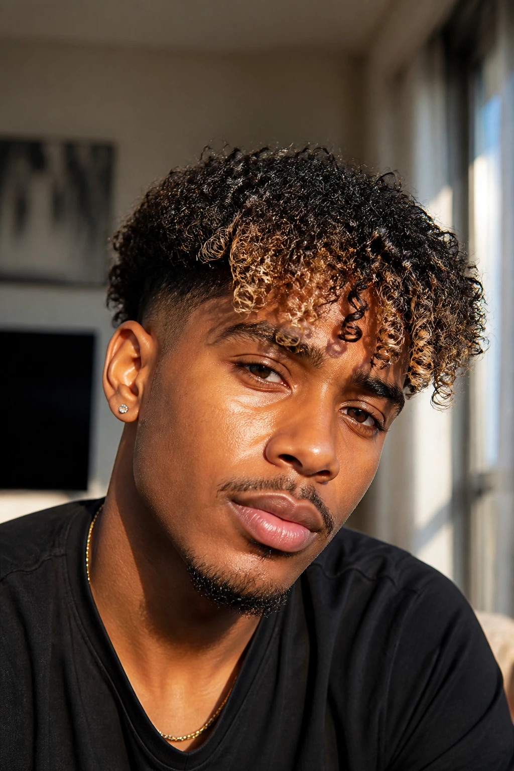 Close-up of a Black man with curly fringe and brown to blonde money piece.