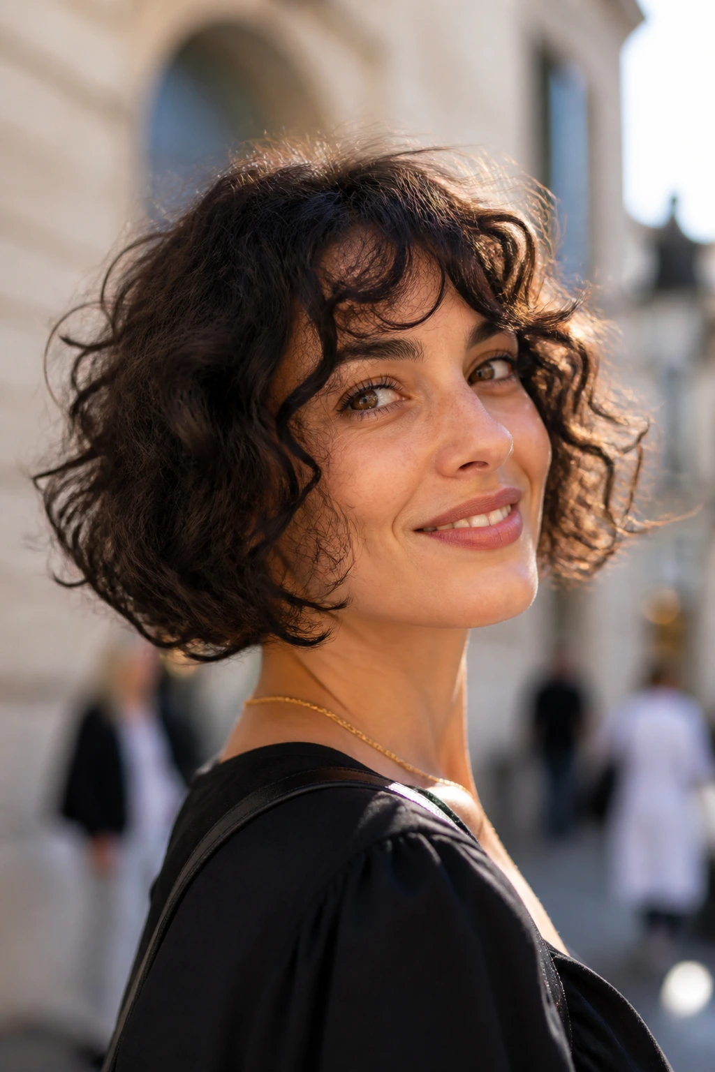 Close-up of a real woman with curly Italian bob and swinging ends on a city street