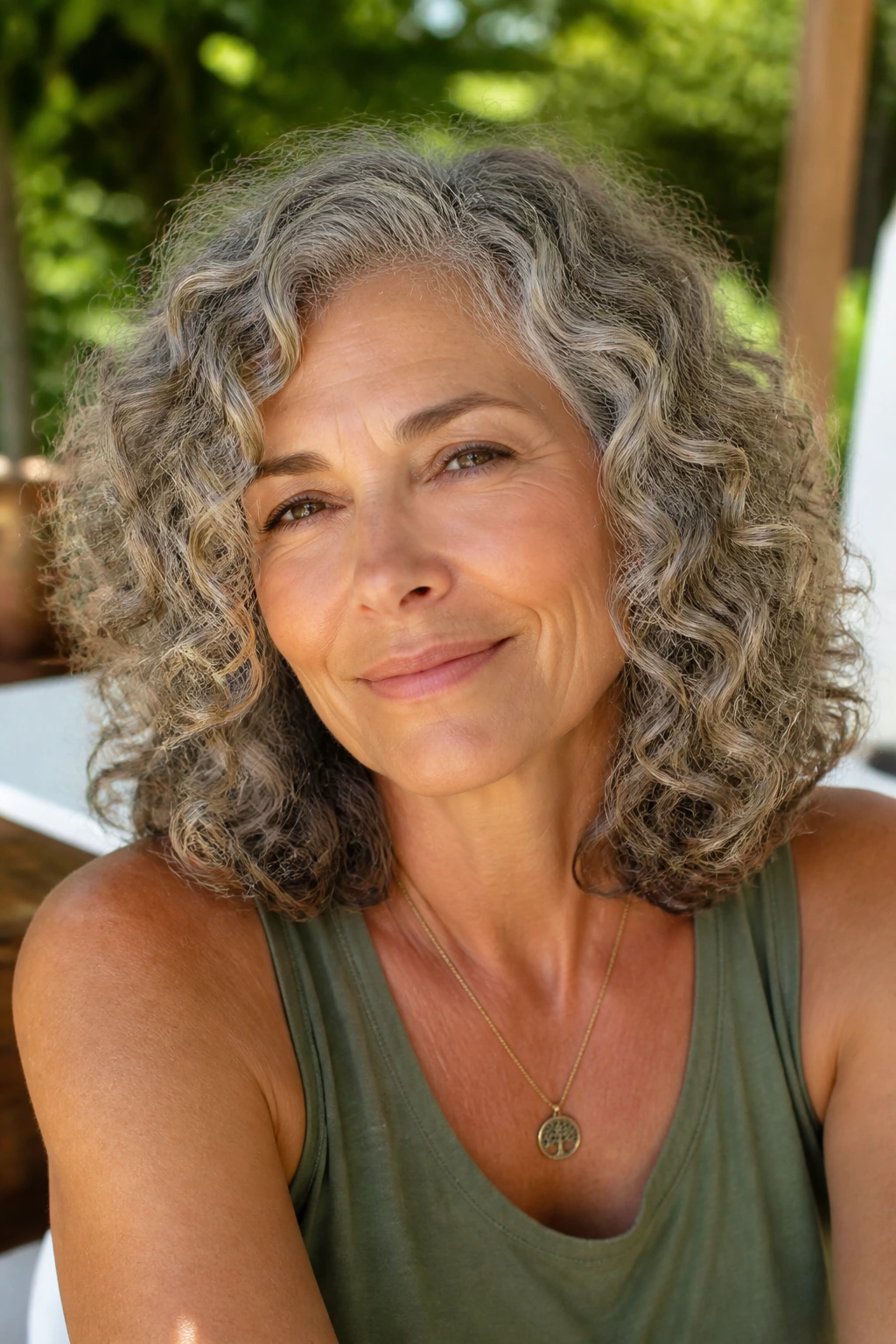 Real woman with shoulder-length curls on a sunlit patio