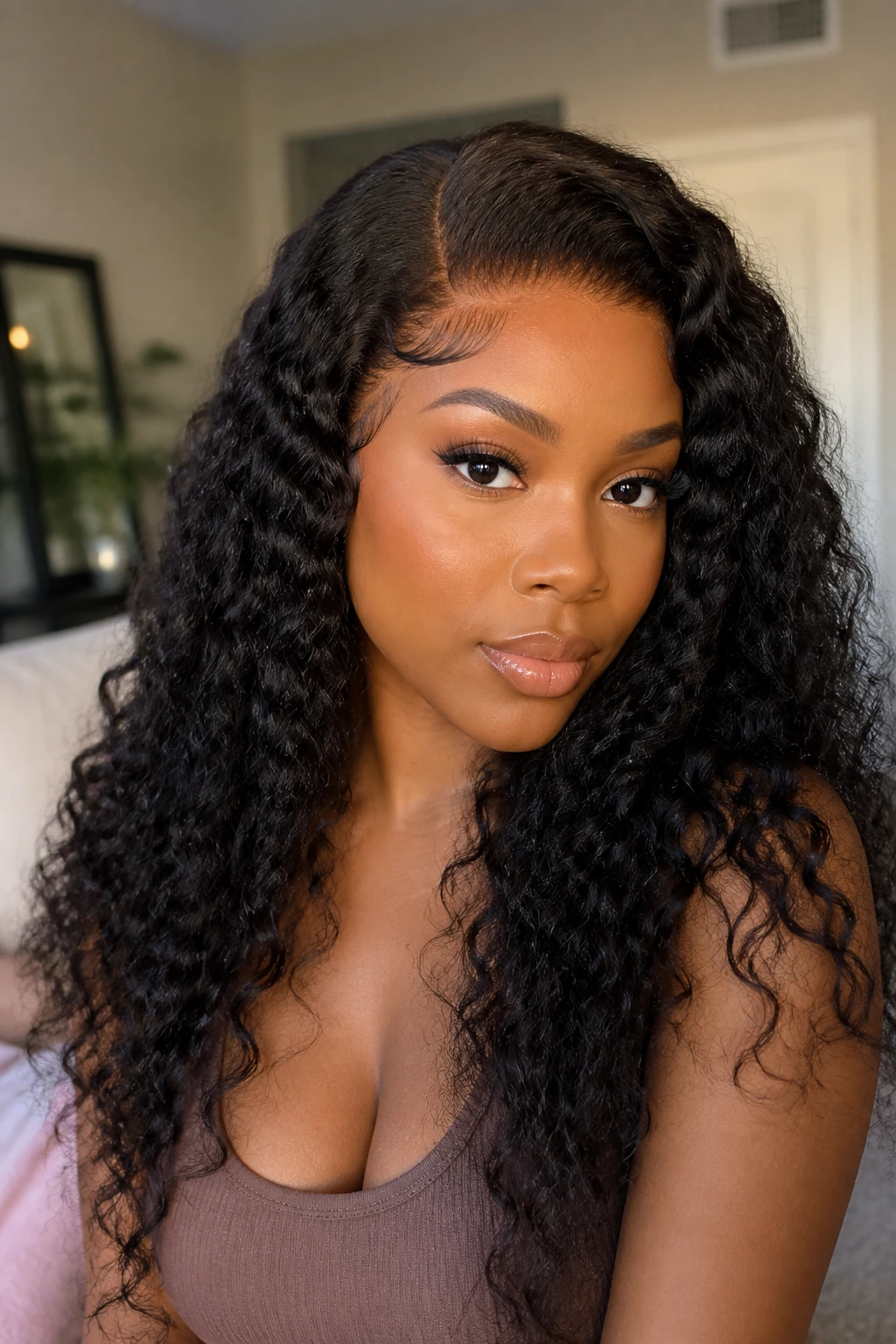 Real person wearing curly wig showing natural lace front in a home setting
