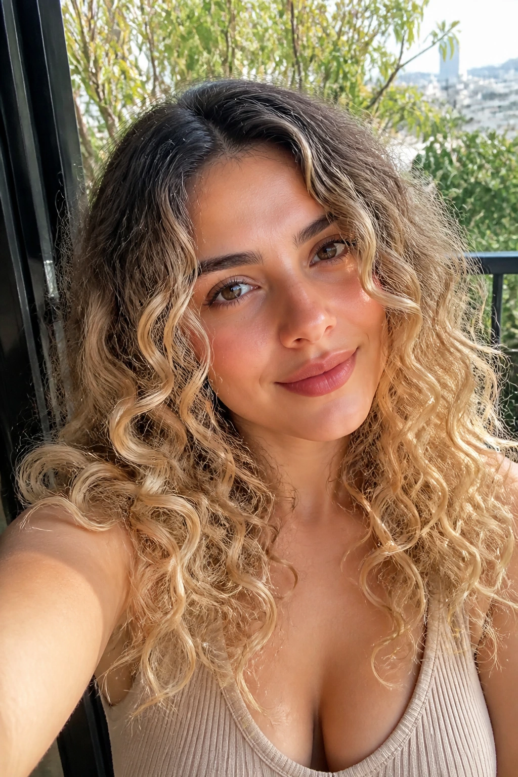 Real person with dark-root champagne curls on a sunlit balcony