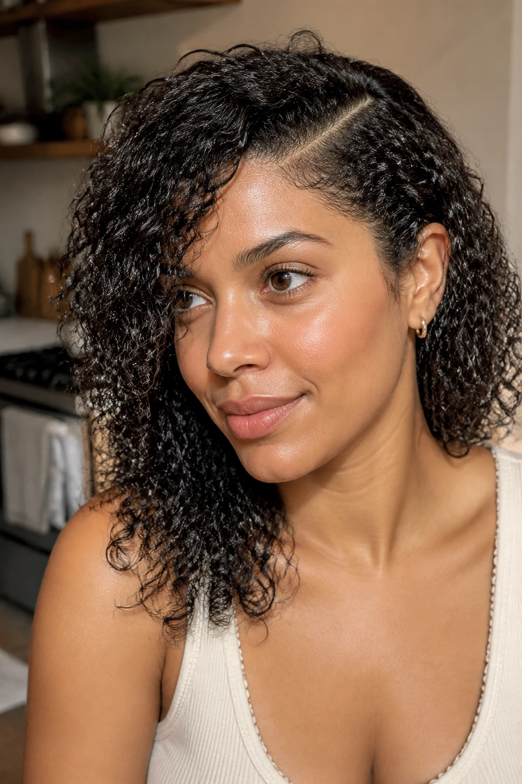 Close-up of a real woman with a deep side part and wash-and-go curls.