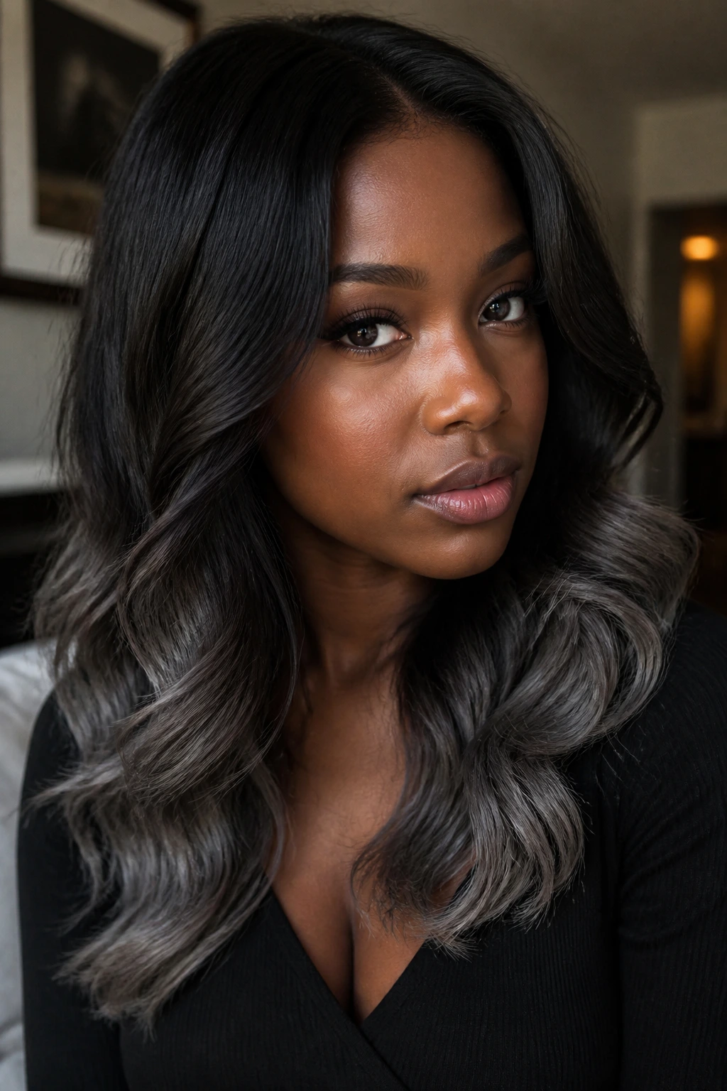 Close-up of a real person showing deep umber hair with grey ends under soft indoor lighting